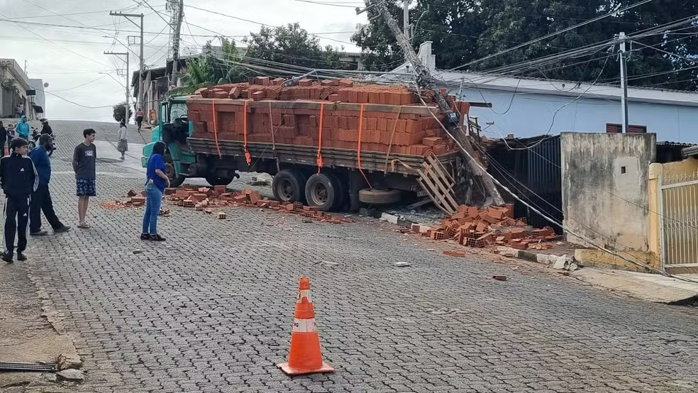 Caminhão carregado de tijolos derruba poste de energia e muro de residência após não aguentar subir morro em Passos - Foto: Helder Almeida