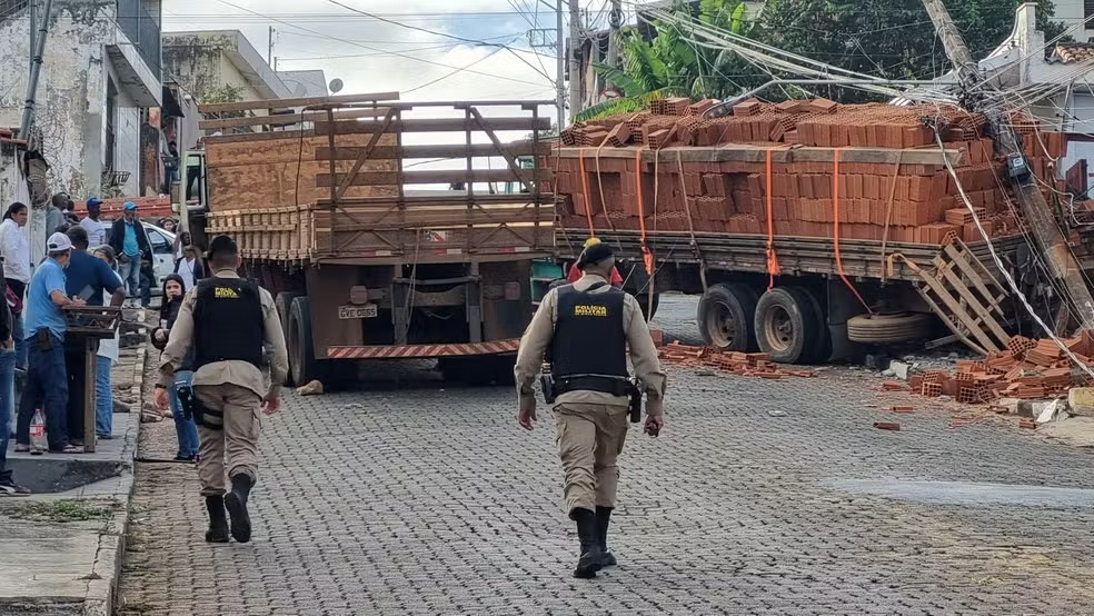 Caminhão carregado de tijolos derruba poste de energia e muro de residência após não aguentar subir morro em Passos - Foto: Helder Almeida